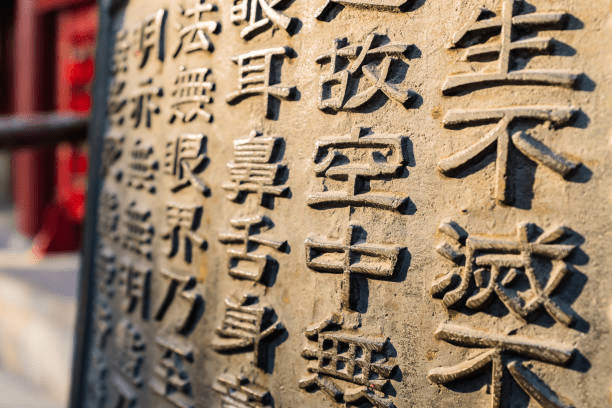 This image depicts chinese characters engraved on stone to accentuate the passage of time and the ancient nature of the language
